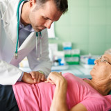 Portrait of doctor palpating near woman's liver