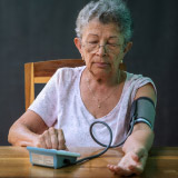 Portrait of woman checking blood pressure at home