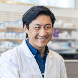 Portrait of community pharmacist with customer