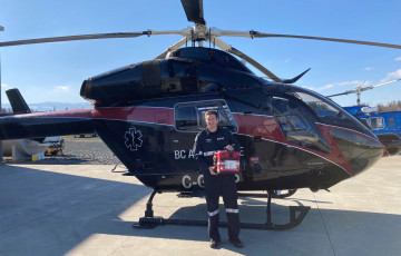 Man standing in front of a helicopter