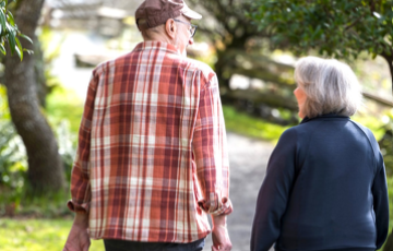 Man and woman walking down a sidewalk in a neighbourhood