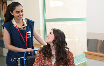 volunteer with younger patient in wheelchair